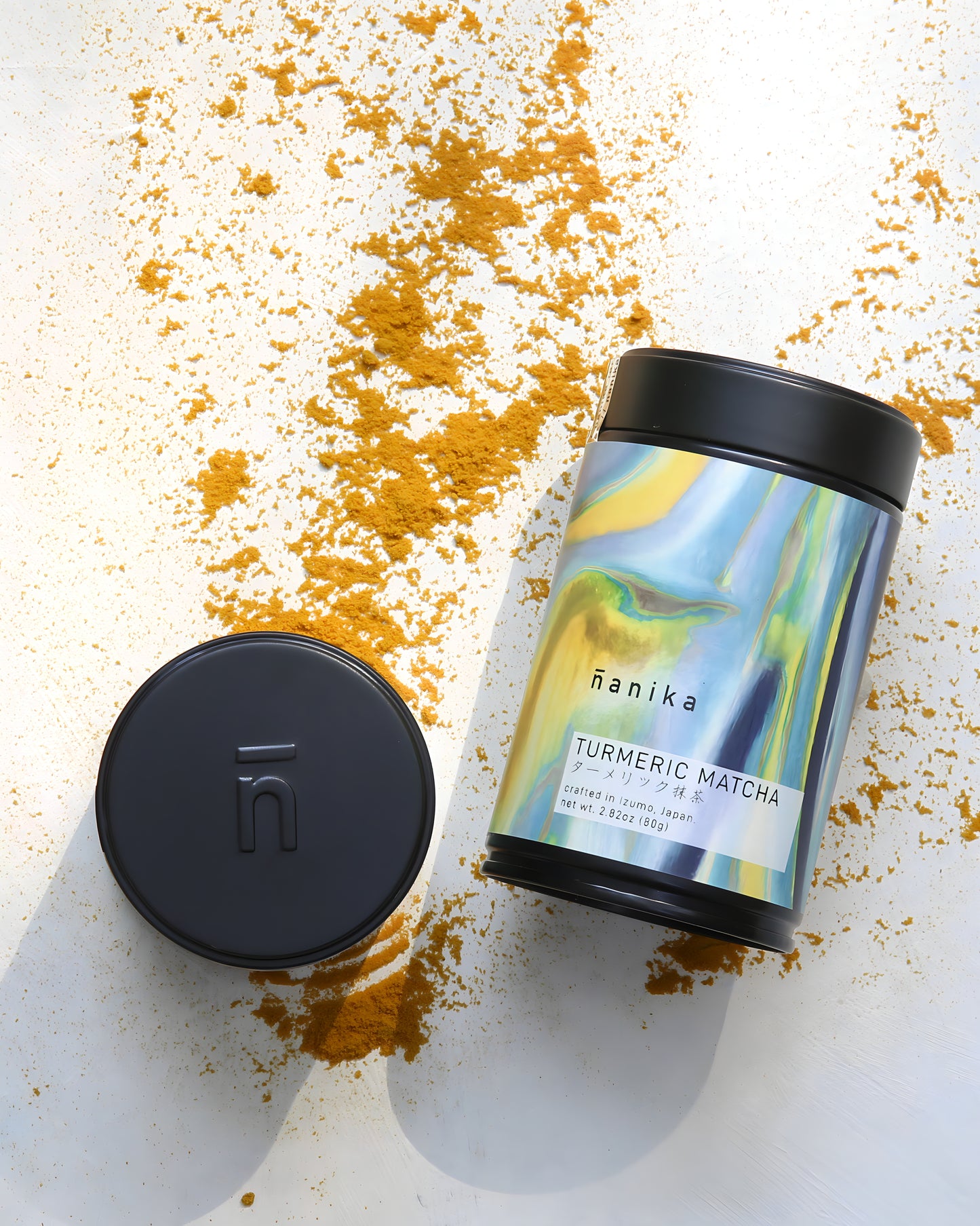 Nanika Turmeric Matcha container with turmeric powder on a white background